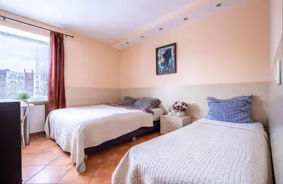 two beds in a room with a window at Mara in Vilnius