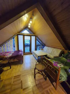 a attic room with two beds and a table at Pas Birute in Kaunas