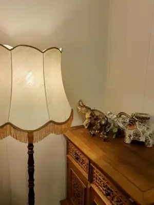 a lamp on a wooden table with stuffed animals on it at Pas Birute in Kaunas