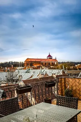 a balcony with a table and chairs and a building at Apartment with a Terrace over the Old Town Two Bedrooms in Kaunas