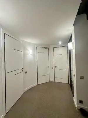 an empty hallway with four white closets in a building at Apartment with a Terrace over the Old Town Two Bedrooms in Kaunas