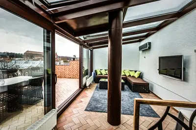a balcony with a couch and a tv on a building at Apartment with a Terrace over the Old Town Two Bedrooms in Kaunas