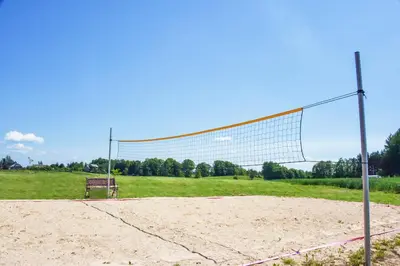 a volleyball net in a field with a bench at Sodyba Puodžių Kaimas in Mackėnai