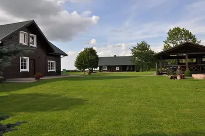 a house with a large yard in front of a house at Sodyba Puodžių Kaimas in Mackėnai