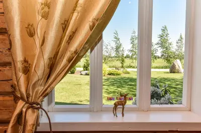 a window with a statue of a deer on a window sill at Sodyba Puodžių Kaimas in Mackėnai