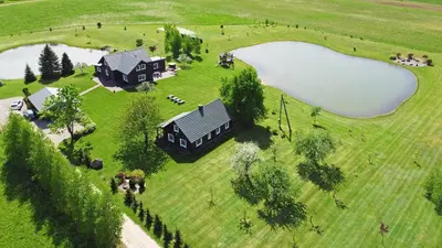 an aerial view of a home with a lake at Sodyba Puodžių Kaimas in Mackėnai
