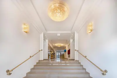 a hallway with stairs and a chandelier at Kesminta Šalčininkai in Šalčininkai