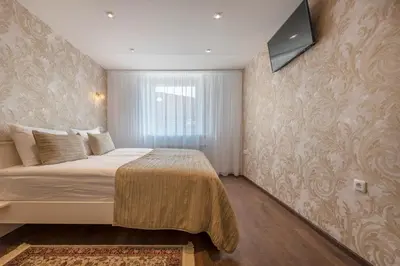 a bedroom with a bed and a television on a wall at Kesminta Šalčininkai in Šalčininkai