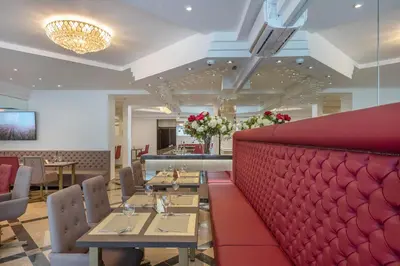 a restaurant with tables and a red wall at Kesminta Šalčininkai in Šalčininkai