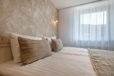 a bedroom with a large white bed with a window at Kesminta Šalčininkai in Šalčininkai