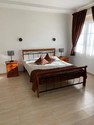 a bedroom with a large bed with two lamps on tables at Prie Žiedo in Trakai