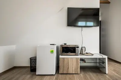 a kitchen with a refrigerator and a microwave at Prie Žiedo in Trakai