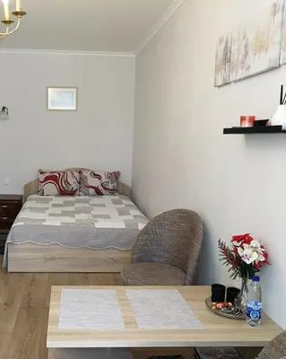 a bedroom with a bed and two chairs and a table at Šiauliai City Apartment in Šiauliai