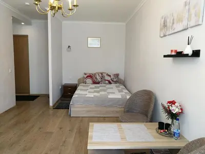 a bedroom with a bed and a table in it at Šiauliai City Apartment in Šiauliai