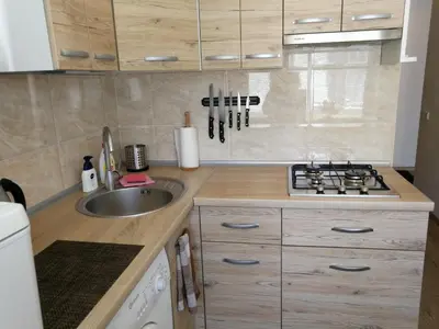 a small kitchen with a sink and a stove at Šiauliai City Apartment in Šiauliai
