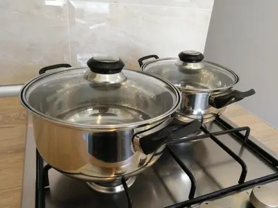 two pots sitting on top of a stove at Šiauliai City Apartment in Šiauliai