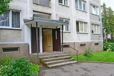a building with a yellow door and stairs in front at Šiauliai City Apartment in Šiauliai