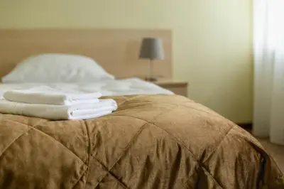 a bed with three towels sitting on top of it at Domus Hotel in Birštonas