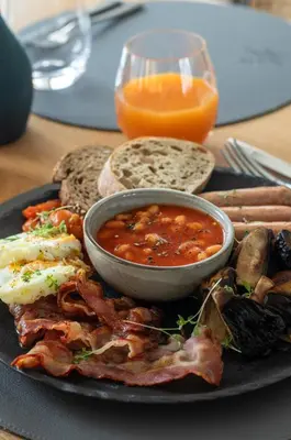 a plate of breakfast food with a bowl of soup and toast at Domus Hotel in Birštonas