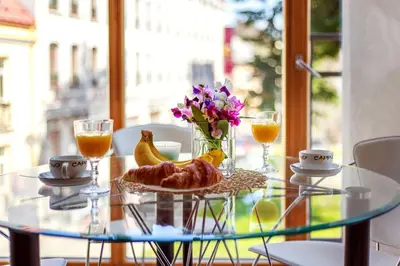a glass table with a plate of food and flowers on it at #stayhere - Cozy & Comfy 1BDR Apartment Vilnius Old Town in Vilnius