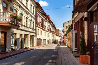 a street with buildings and a child riding a scooter at #stayhere - Cozy & Comfy 1BDR Apartment Vilnius Old Town in Vilnius
