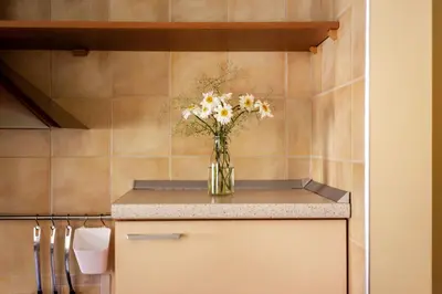 a vase of flowers on a counter in a kitchen at #stayhere - Cozy & Comfy 1BDR Apartment Vilnius Old Town in Vilnius
