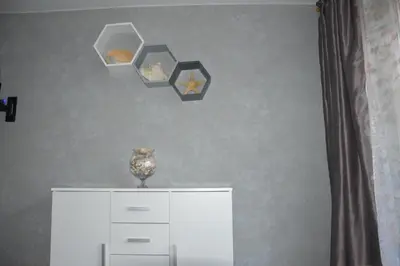 a white cabinet with two shelves and a vase on it at Alanta in Druskininkai