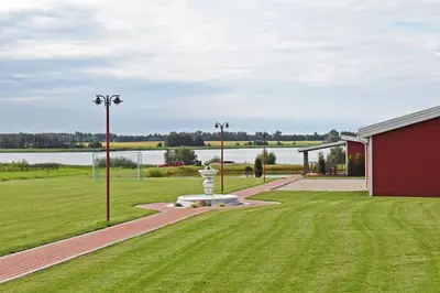 a park with a fountain and a red building at Villa Ievynė in Paežeriai