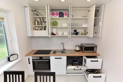 a kitchen with white cabinets and a counter top at Villa Ievynė in Paežeriai