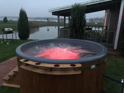 a large barrel fire pit in a yard at Villa Ievynė in Paežeriai