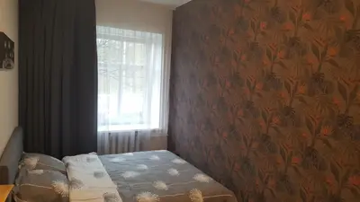 a bedroom with a bed with a floral wallpaper at Apartment on Kudirkos 20 in Vilnius