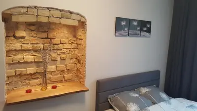 a bedroom with a brick wall next to a bed at Apartment on Kudirkos 20 in Vilnius