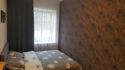 a bedroom with a bed with a floral wallpaper at Apartment on Kudirkos 20 in Vilnius