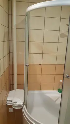 a shower with a glass door next to a sink at Apartment on Kudirkos 20 in Vilnius