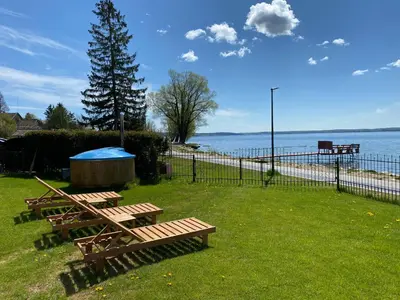 two picnic tables in the grass near the water at Villa in Vistytis in Vištytis