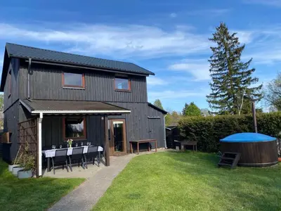 a black house with a table and chairs in the yard at Villa in Vistytis in Vištytis