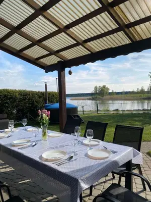 a table with wine glasses and flowers on a patio at Villa in Vistytis in Vištytis