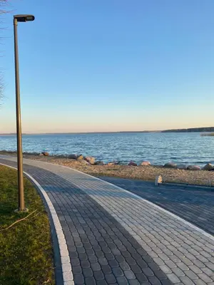 a brick sidewalk next to the water with a street light at Villa in Vistytis in Vištytis
