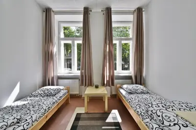 a bedroom with two beds and two windows at Laisves Avenue Hostel 