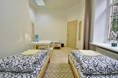 a room with two beds and a table in it at Laisves Avenue Hostel 