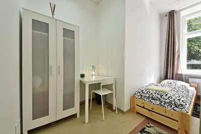 a bedroom with a table and a bed and a desk at Laisves Avenue Hostel 