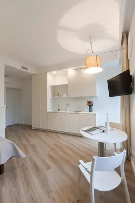 a living room with a table and a kitchen at 9010 Apartments in Vilnius