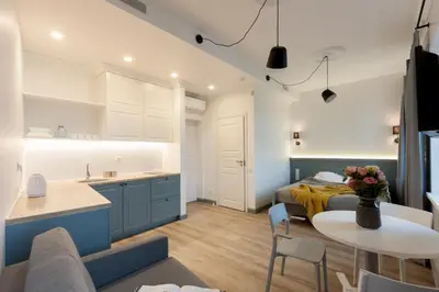 a kitchen and living room with a bed and a table at 9010 Apartments in Vilnius