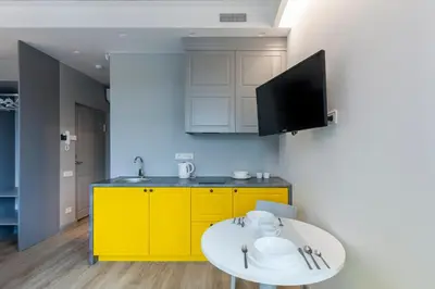 a kitchen with yellow cabinets and a white table at 9010 Apartments in Vilnius