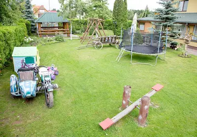a yard with a motorcycle and a playground at Mamos virtuve in Avižieniai