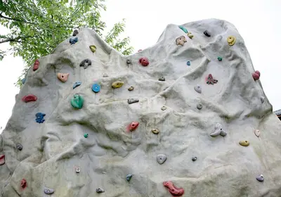 a rock climbing wall with many climbers on it at Mamos virtuve in Avižieniai