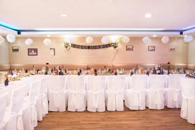 a banquet hall with white tables and white chairs at Mamos virtuve in Avižieniai