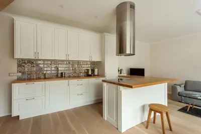 a kitchen with white cabinets and a wooden counter top at #stayhere - Spacious 2BDR Two Floor I Heart of Old Town in Vilnius