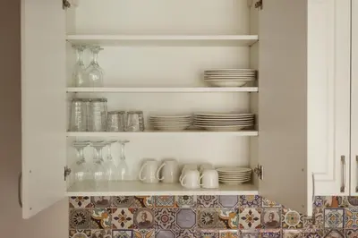 a kitchen cabinet with plates and glasses and dishes at #stayhere - Spacious 2BDR Two Floor I Heart of Old Town in Vilnius