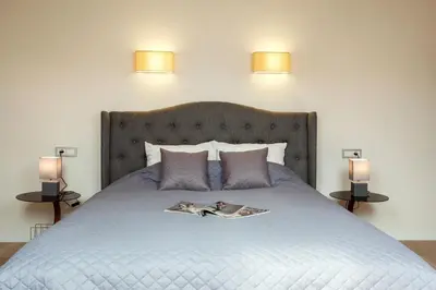 a bed with two lamps and a magazine on it at #stayhere - Spacious 2BDR Two Floor I Heart of Old Town in Vilnius